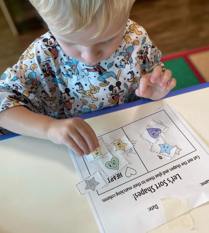 Child completing a shape sorting activity at Tiny People University Childcare Center in Magnolia, TX.